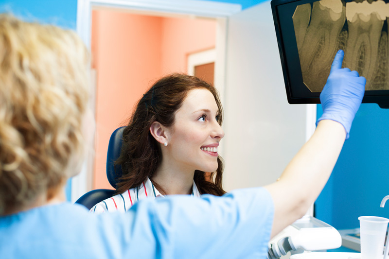Dentist pointing to digital X-rays, offered by Oak Park Dental in Salem, OR